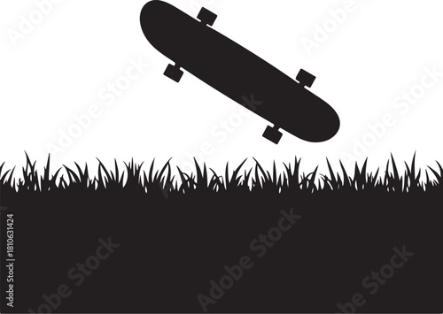 Black skateboard in mid air above grass silhouette