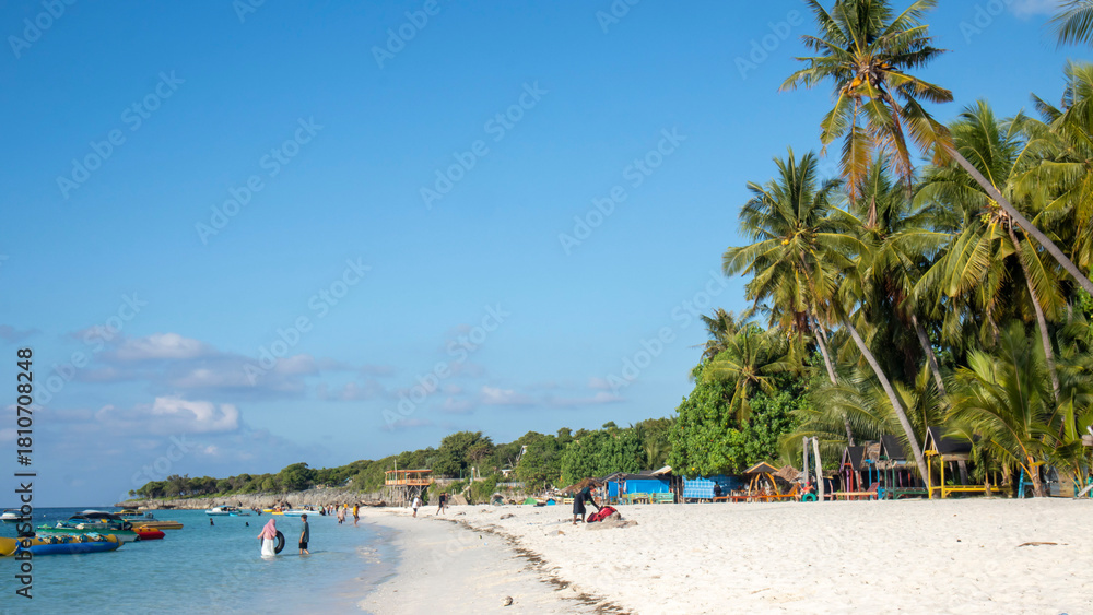 Naklejka premium tropical beach with coconut palm trees and blue sky at Bara beach, Bira Bay