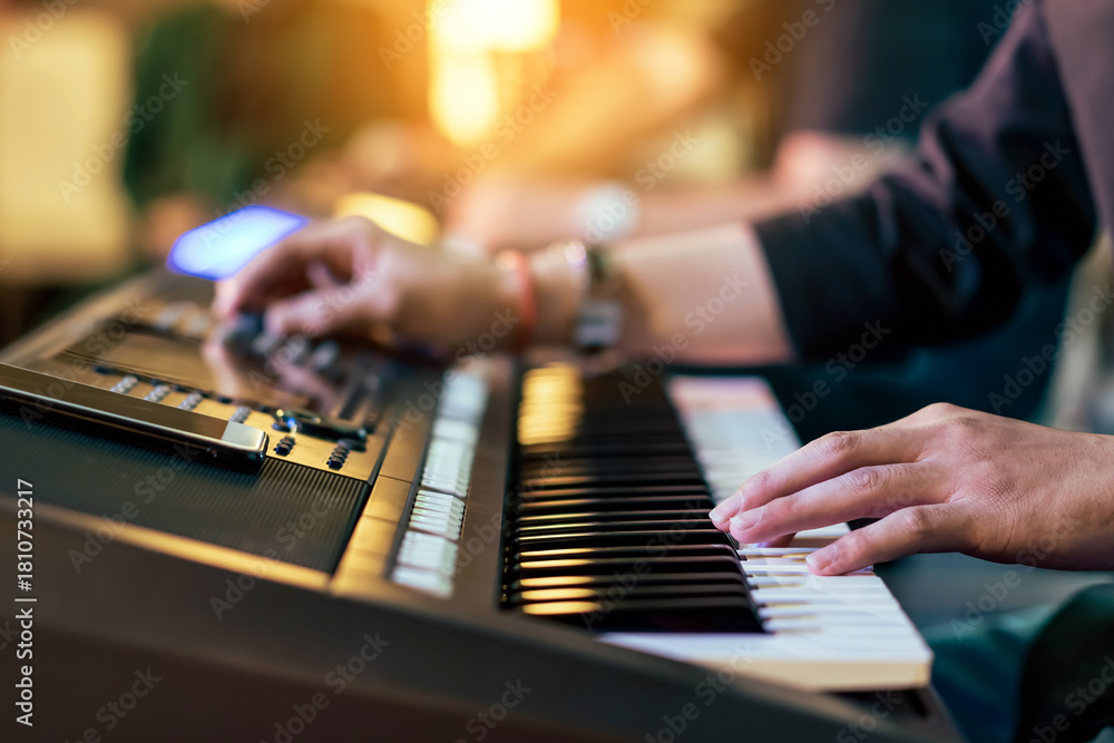 Obraz premium Hands of male musician press digital electronic keyboard synthesizers on concert stage. Pianist man hands play the keys of electronic piano. Piano music pianist hand playing. Selective focus on hand.