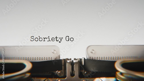 Old mechanical typewriter typing Sobriety Goals in a close-up view, with metal letters striking the white paper.