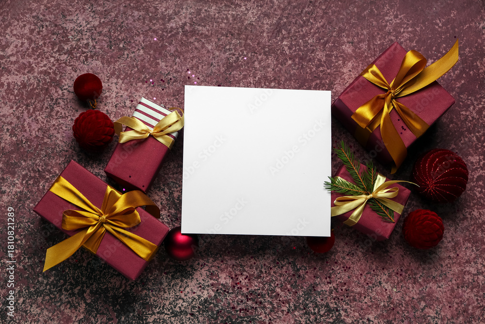 Naklejka premium Blank greeting card with Christmas decorations and gift boxes on grunge red background