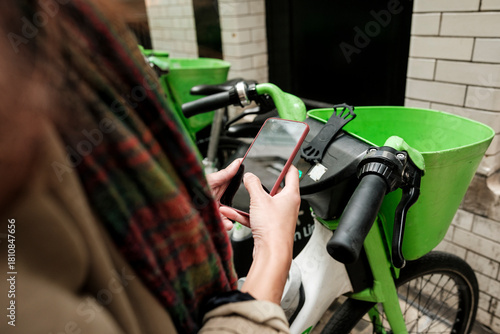 Woman using smartphone app for urban bike-sharing service