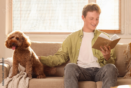 Young man reading book with...