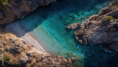 High-angle view of a secluded cove with turquoise water and rocky shoreline.