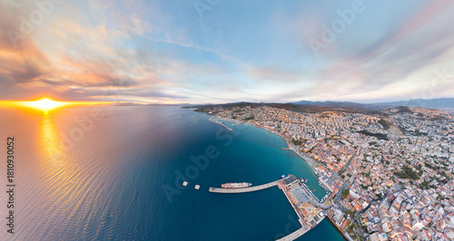 Fototapeta Naklejka Na Ścianę i Meble -  Kusadasi, Turkey. Aerial panoramic view with sun, bay, marina, beaches with promenade, port and cruise ship. Summer coastal scenery. Aerial view.