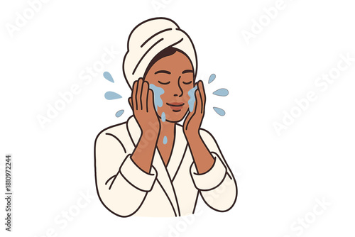 Young woman in bathrobe and towel turban washing face during relaxing beauty routine