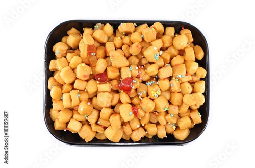 Struffoli, also known as Honey balls, in a black serving tray on white background. It is a traditional Neapolitan christmas dish.