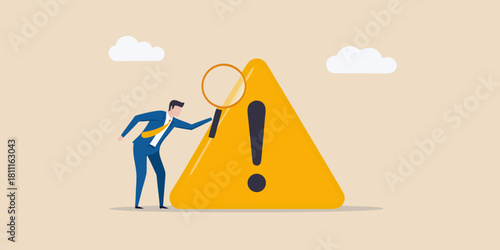 Businessman inspecting a warning sign with a magnifying glass risk assessment