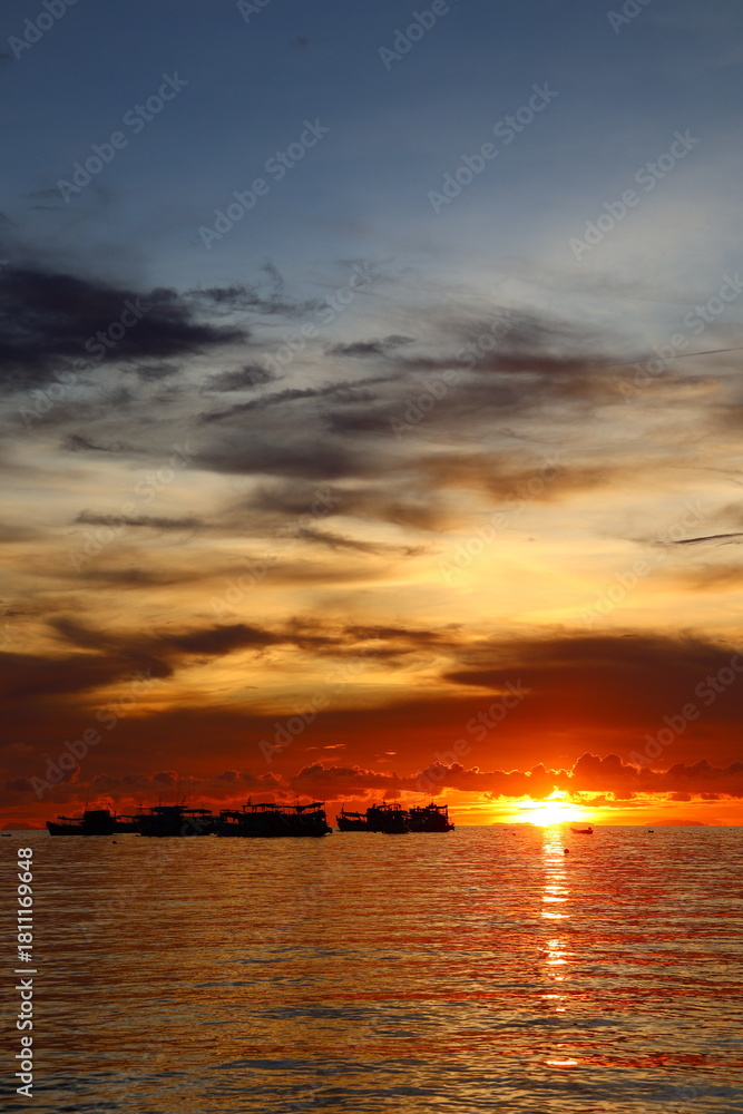 Naklejka premium Sunset boat floating over the peaceful tropical sea