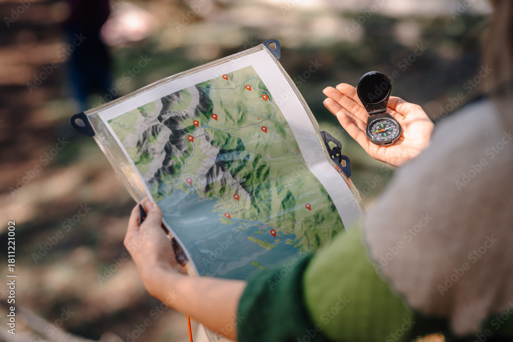 Naklejka premium Person navigating outdoors using map and compass