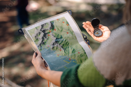 Person navigating outdoors using map and compass