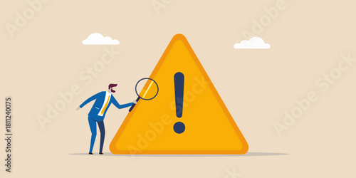 Businessman inspecting a large warning sign with a magnifying glass