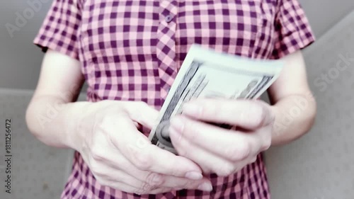 Concept of financial control and personal wealth in action. Close-up of woman counting one hundred dollar bills.