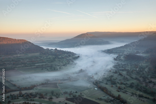 Blick auf das nebelverhangene Neidlinger Tal im Herbst zum Sonnenaufgang, Schwäbische Alb.