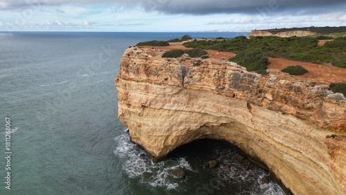 Rocky coastal cliff with natural arch in Faro, Algarve, Portugal