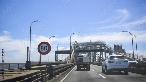 Traffic on Auckland harbour bridge. 80km per hour speed limit sign on the road. Auckland. New Zealand.