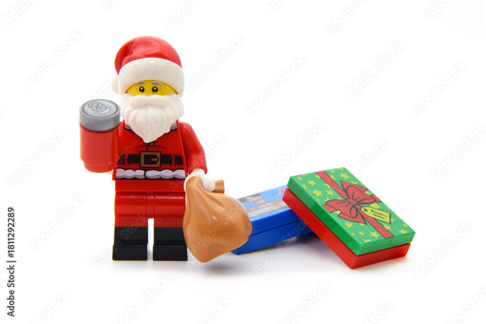 Naklejka premium Editorial illustrative image of lego minifigure of Santa Claus with red Cola cans and present boxes isolated on white.