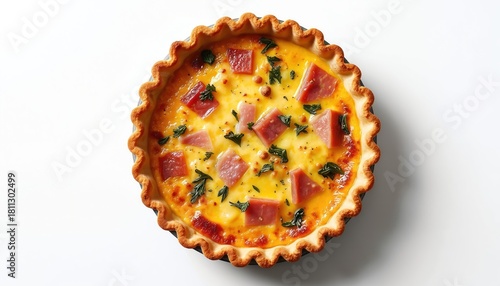 Whole round quiche lorraine with ham and herbs rests on a clean white surface. Savory pie has golden crust filled with creamy egg and cheese mixture.