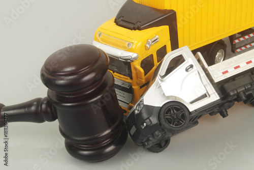 Judge gavel and container carrier hits truck on grey background. Legal proceeding traffic accident concept.