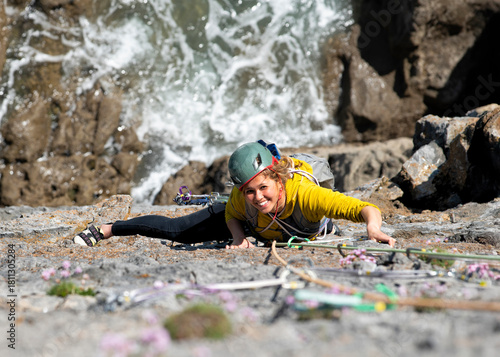Woman climbing Brazen Buttress in Pembrokeshire Wales with safety helmet