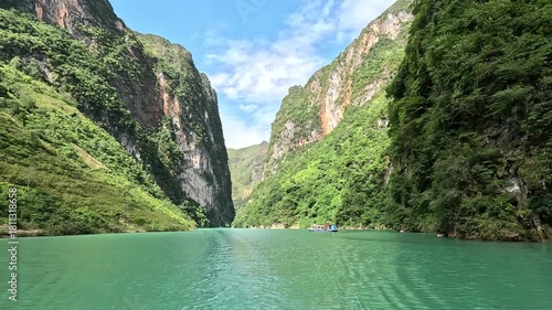 The Nho Que River flows between steep karst mountains in Ha Giang, Vietnam. Turquoise water, narrow canyon walls, and dramatic scenery create a stunning and immersive travel footage.