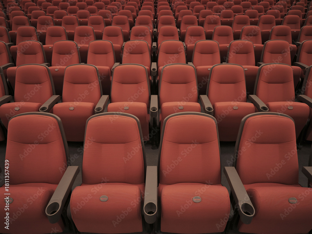 Naklejka premium Rows of plush red theater seats await moviegoers, promising an immersive cinematic experience with comfort and style, perfect for advertising.