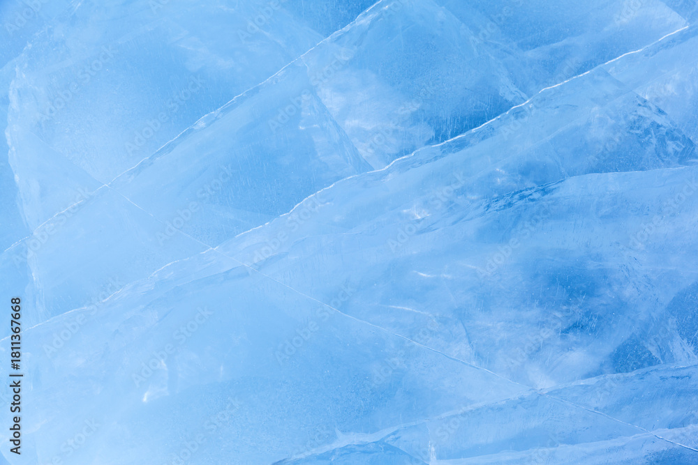 Obraz premium Winter natural ice background of frozen Baikal Lake in cold day. Blue ice texture with pattern of white cracks. Natural icy backdrop for Christmas design. Mockup, copy space, flat lay, blank, top view