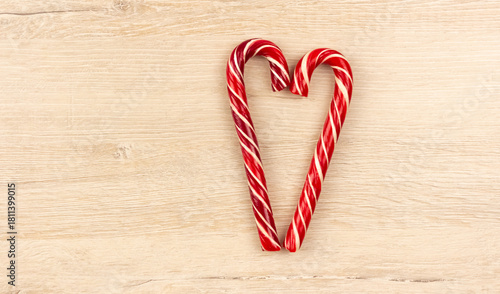 Heart made from Christmas candy canes on a wooden background