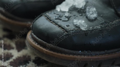 Wallpaper Mural Close-up of melting snow on black leather boots indoors Torontodigital.ca