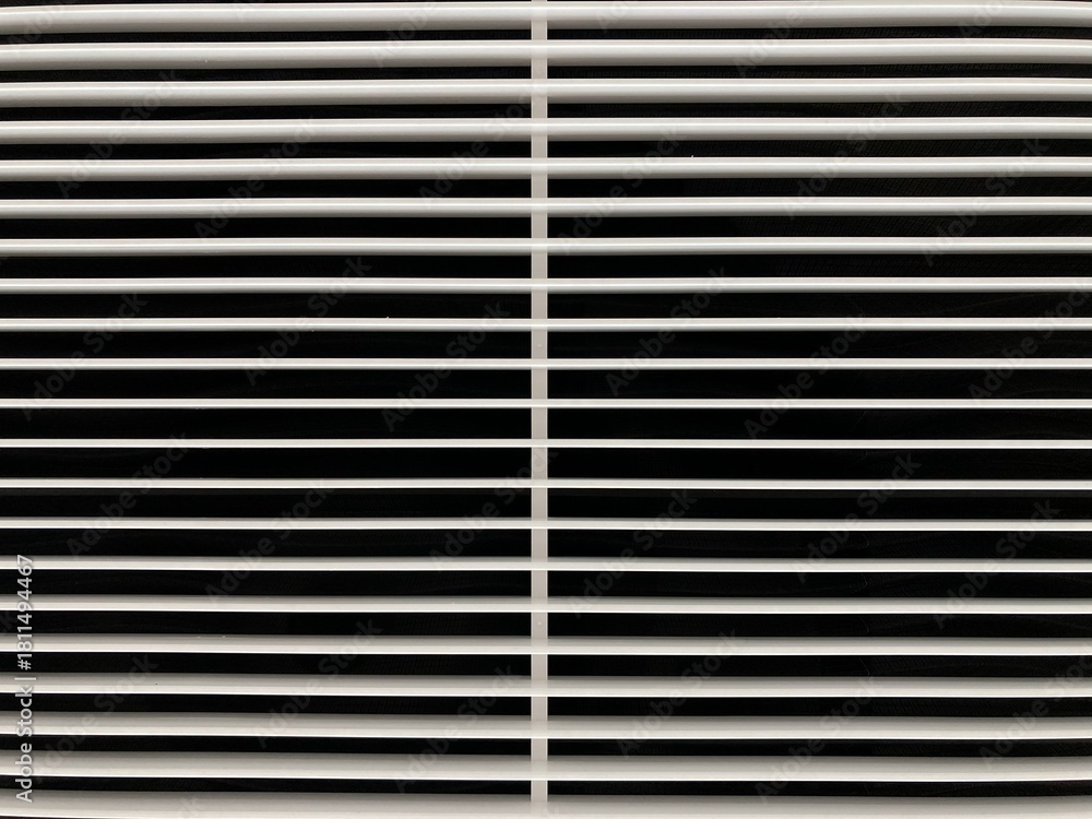 Obraz premium Abstract geometric background featuring a symmetrical pattern of clean, parallel white louvers and dark shadows from a modern ventilation grille