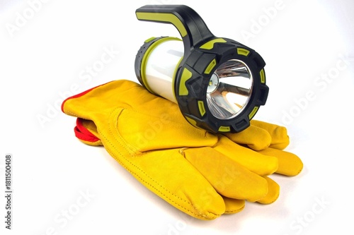 leather work gloves and a hand held flash light on a white background 