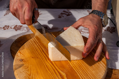 man cutting cheese with knife