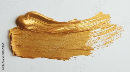 Gold paint brush strokes on white paper with smooth texture and slight foreshortening in some areas.