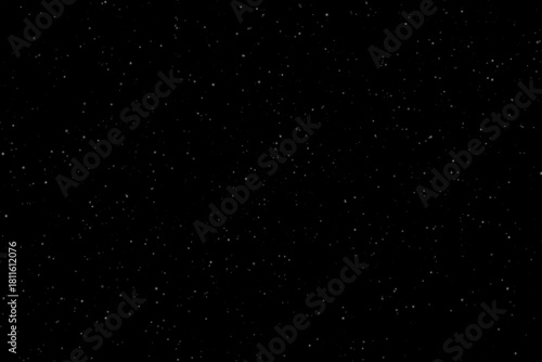 Soft white dust particles of various sizes and transparencies scattered on a solid black background. Minimalistic texture without flares or highlights, ideal for abstract and festive designs.