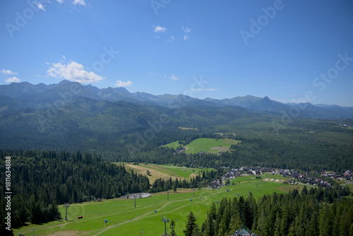 Fototapeta Naklejka Na Ścianę i Meble -  High Tatras and Male Ciche ski resort seen from a metal observation tower with a modern glass terrace offering a stunning panorama at Poronin, Poland. Majestic mountains peaks of High Tatra moutnains.