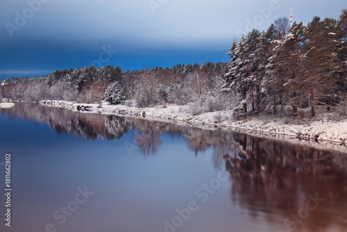 Wallpaper Mural Serene winter landscape featuring a calm river reflecting snow-covered trees under a twilight sky, creating a tranquil atmosphere Torontodigital.ca