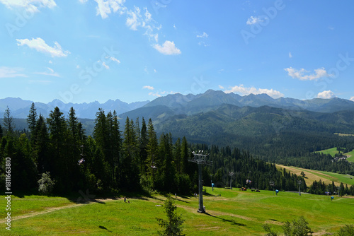 Fototapeta Naklejka Na Ścianę i Meble -  High Tatras and Male Ciche ski resort seen from a metal observation tower with a modern glass terrace offering a stunning panorama at Poronin, Poland. Majestic mountains peaks of High Tatra moutnains.