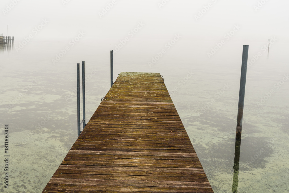 Naklejka premium Foggy wooden jetty in Hemmenhofen, Hoeri peninsula, Lake Constance, Baden-Wuerttemberg, Germany