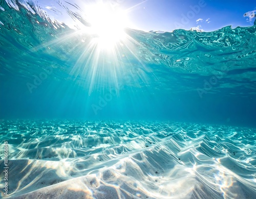 Underwater view sun rays filtering through clear, turquoise water