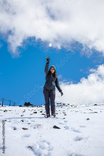 Joyful woman playing with snow in the mountains