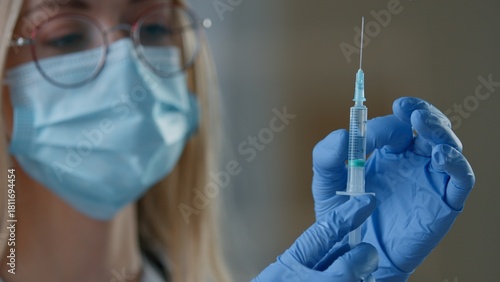 Close up Caucasian woman doctor in medical face mask holding syringe injection vaccination in clinic nurse female girl preparing for vaccine remedy covid19 medication medicine health care antivirus