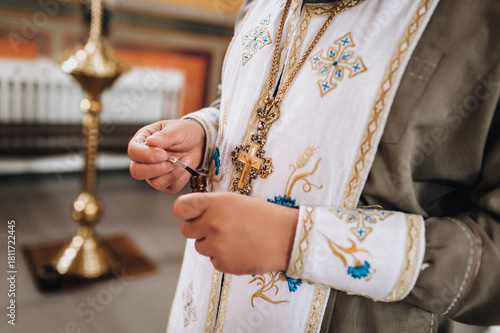 Εκτύπωση καμβά A photograph of a Christian Orthodox priest with a cross on his cassock and anointing oil in his hands for baptism