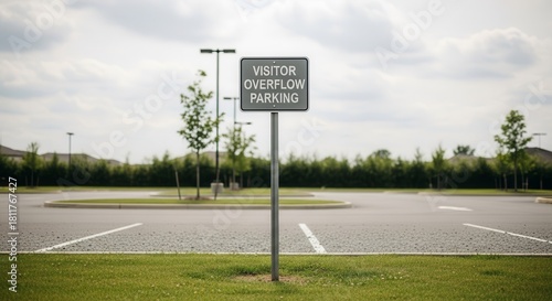 Fototapeta Naklejka Na Ścianę i Meble -  Visitor Parking Sign With Empty Spaces In An Overflow Lot On A Cloudy Day