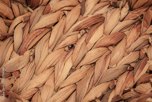 Macro photo of texture of a woven wicker or straw basket. Showing natural earthy tones, fibers and intricate handwoven craftsmanship. Representing of rustic design and traditional handmade artistry.