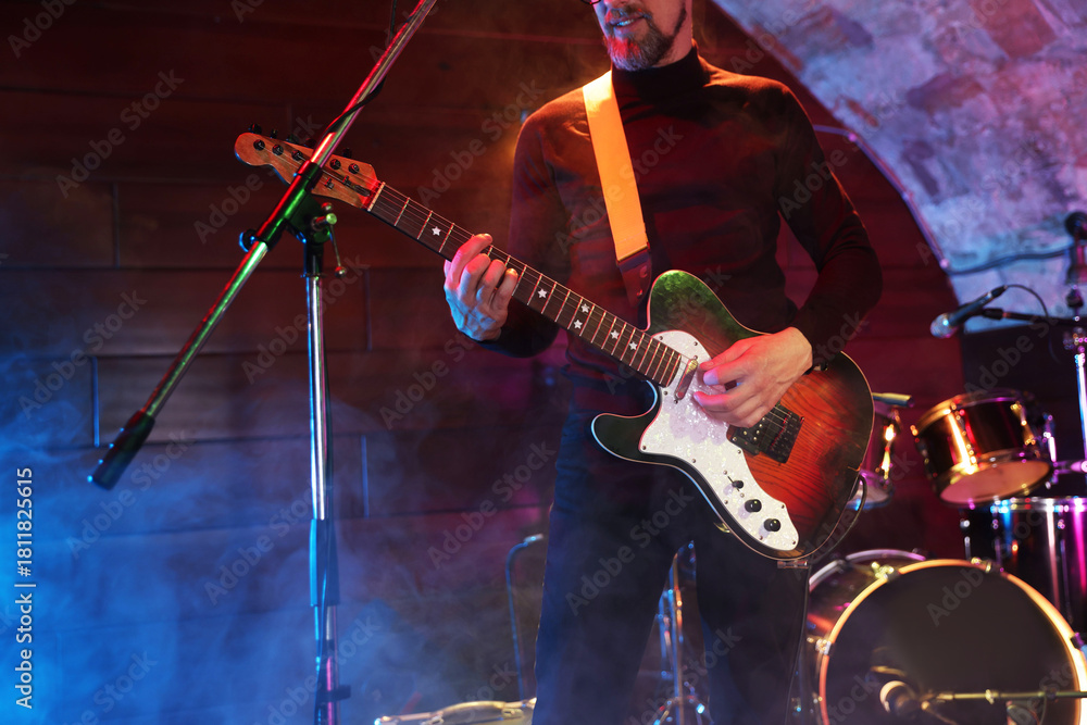 Obraz premium Man playing electric guitar on stage with smoke, closeup