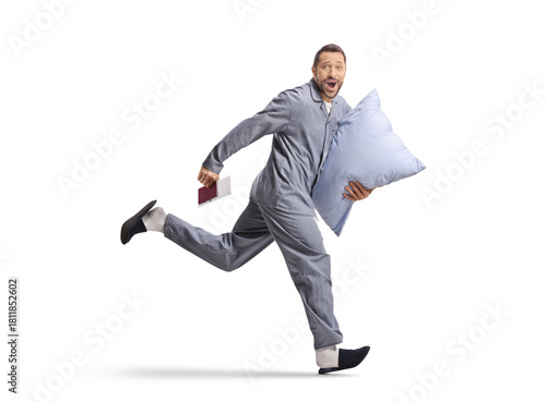 Photos Full length shot of a man in pajamas running with pillow and passport