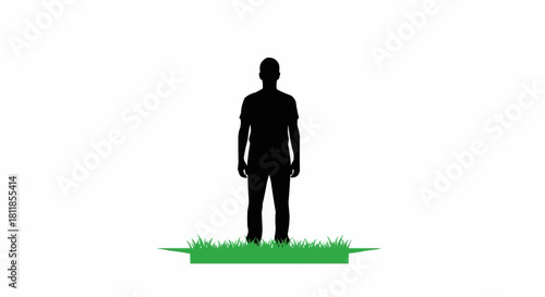 Black silhouette of a man standing still on a patch of grass.