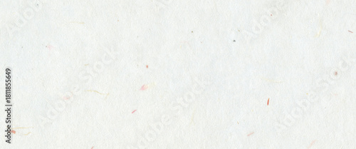 White handmade paper with subtle fiber textures and small colorful flecks. Organic and recycled mulberry paper background concept for craft art