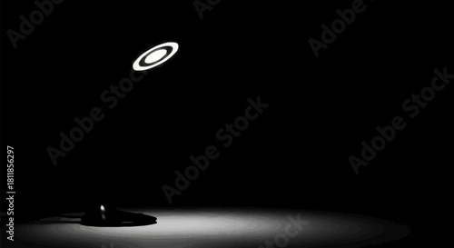 A modern minimalist ring lamp illuminates a dark space.