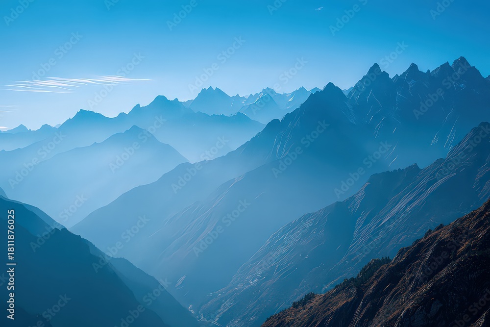 Obraz premium Layered Mountain Range in Blue Hues with Misty Valleys and Forested Slopes Under a Clear Sky Early Morning